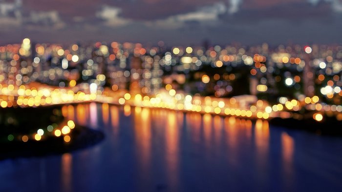 City bokeh lights over water at night
