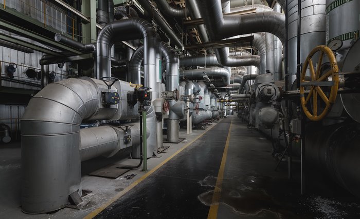 Industrial factory interior with large pipes and valves