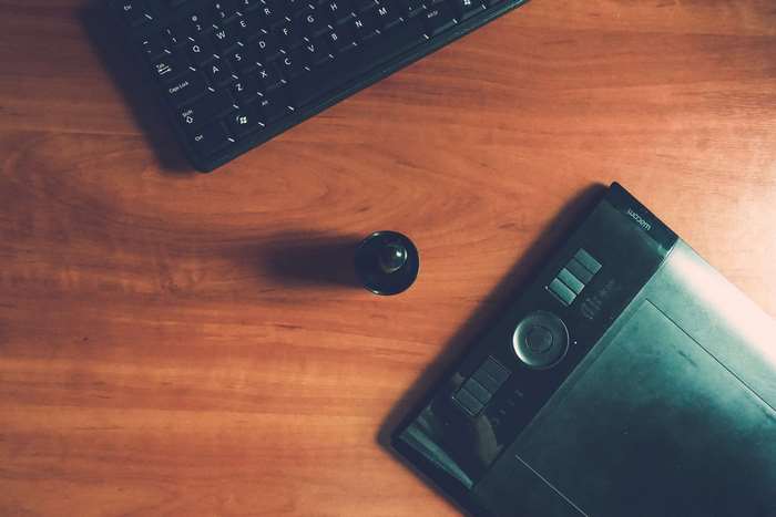 Wacom tablet and keyboard on a wooden desk