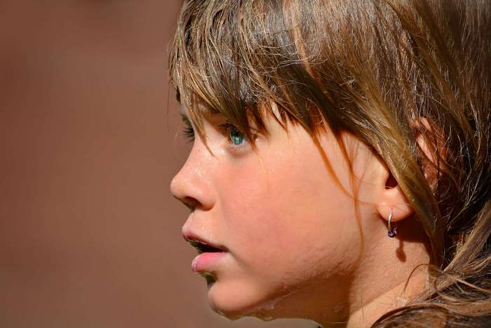 Close up profile of a wet child with blue eyes