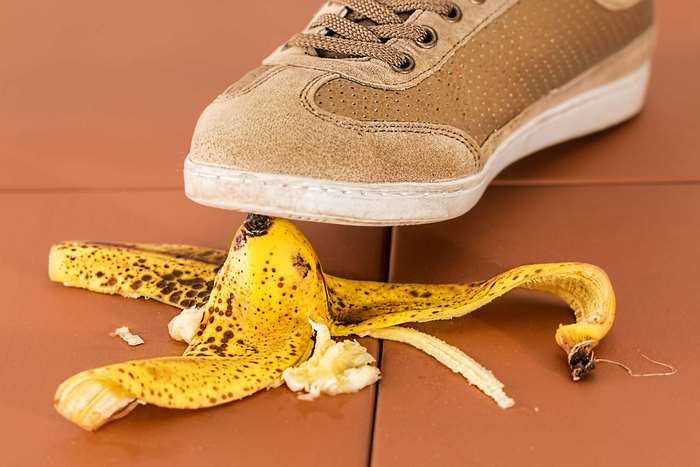 Shoe stepping on a slippery banana peel