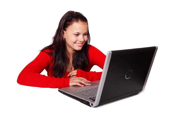 Young woman in red top using a laptop
