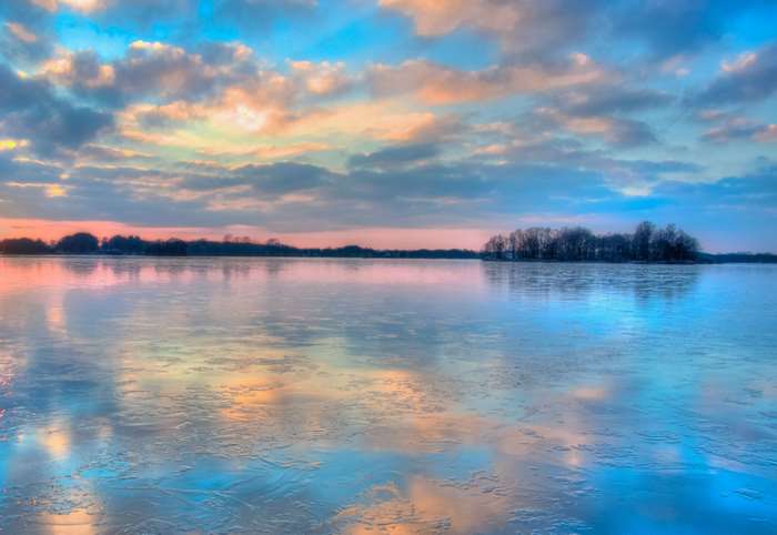 Frozen lake reflecting colorful sunset sky