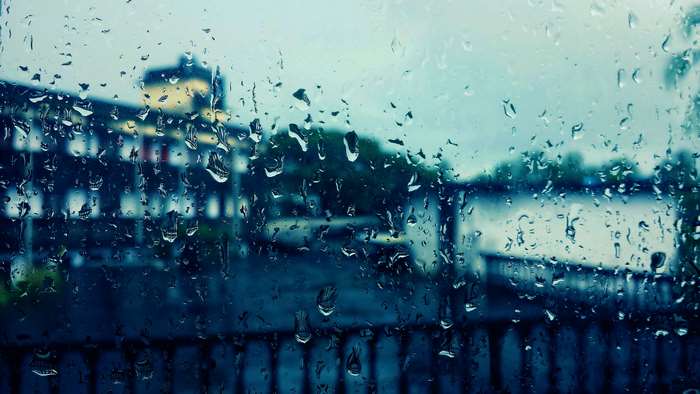 Rain on window with building and water