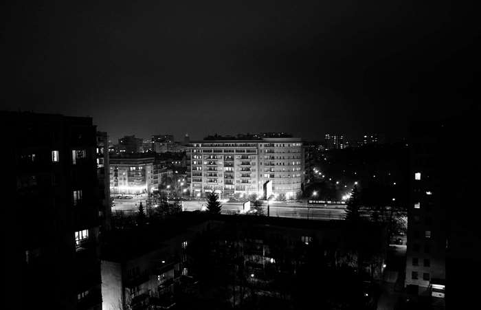 Cityscape at night with illuminated buildings and streetlights
