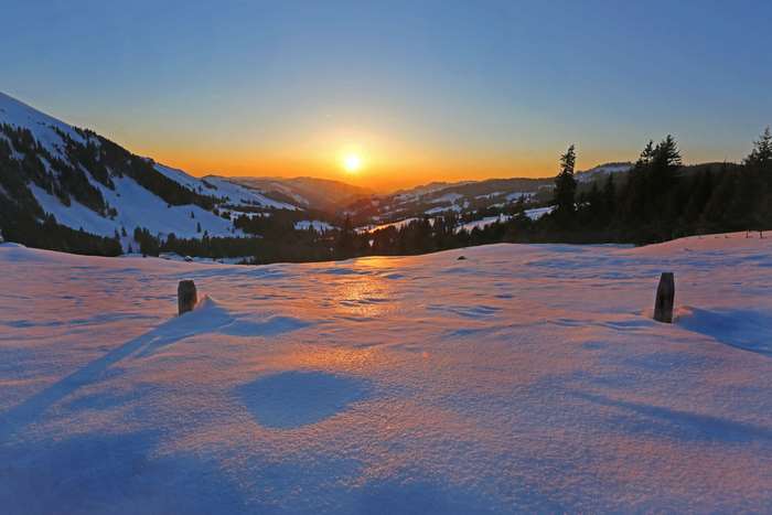 Snowy mountain landscape at sunrise or sunset