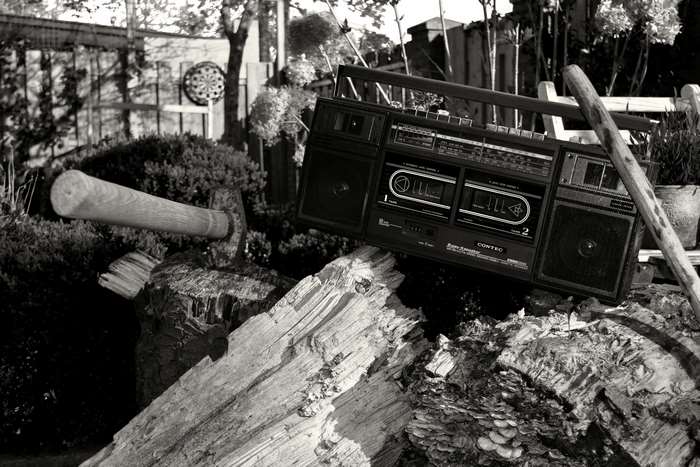 Vintage cassette player on logs with axe