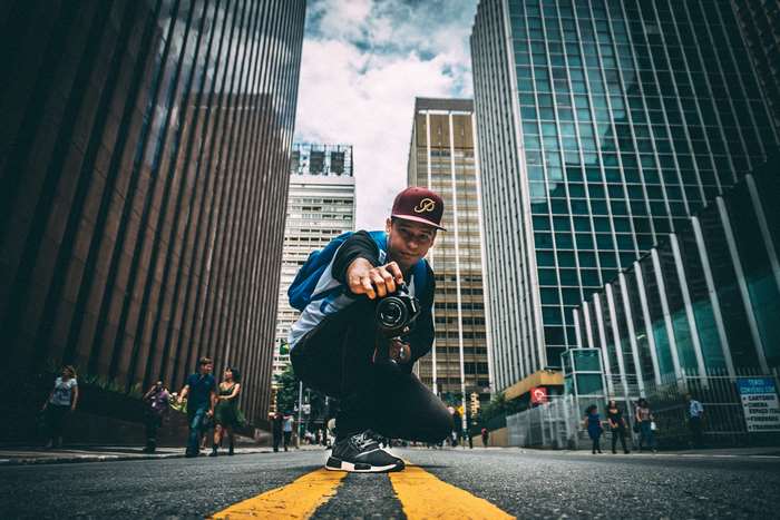 Photographer with camera in urban city street low angle shot