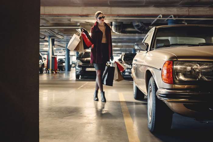 Woman with shopping bags in a parking lot