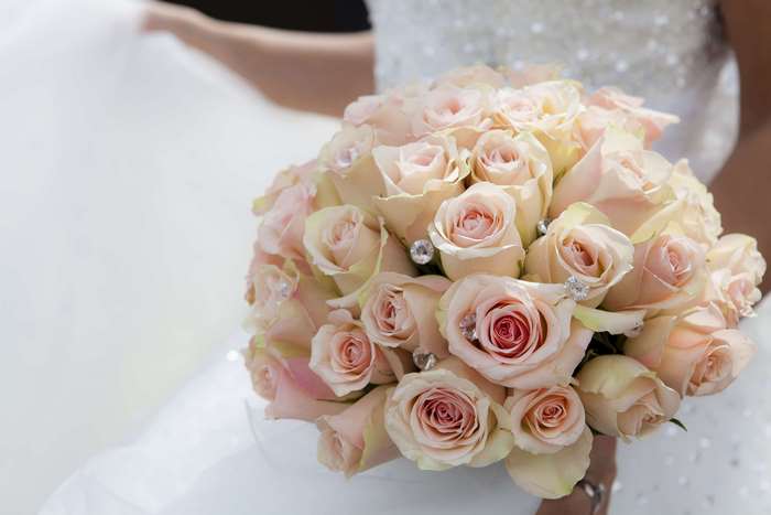 Bride holding a bouquet of pink roses with diamonds
