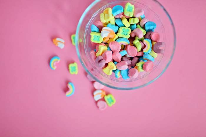 Lucky Charms marshmallows in a glass bowl on pink background