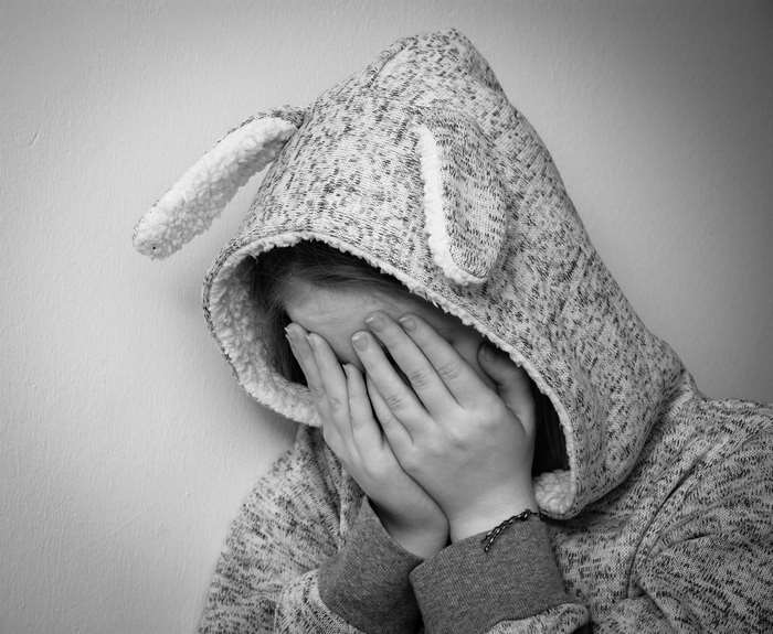 Child in bunny hoodie covering face