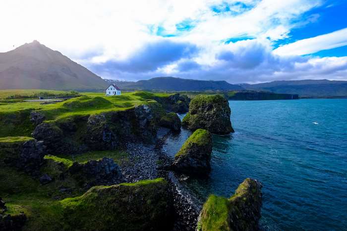 White house on a grassy cliff overlooking the ocean