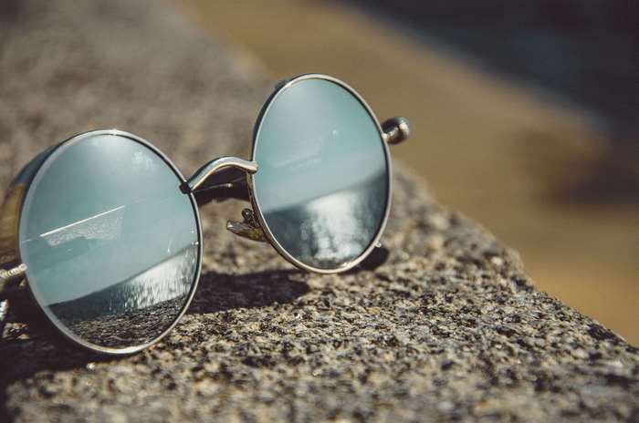 Round sunglasses with reflection on stone