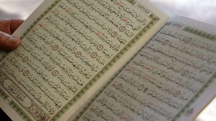 Person reading the Quran 4K