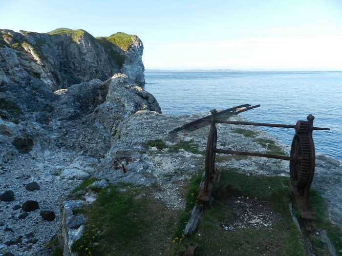 Rusty winch on a cliff overlooking the ocean in Ireland 4K