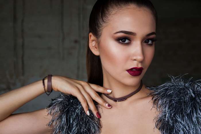 Woman with dark lipstick and feathered boa