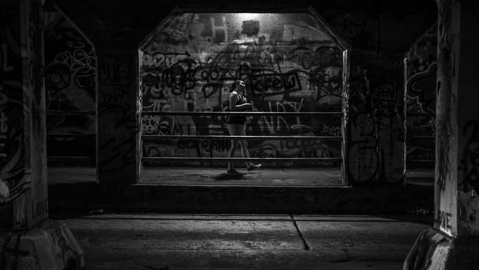 Person standing in a graffiti-covered abandoned building