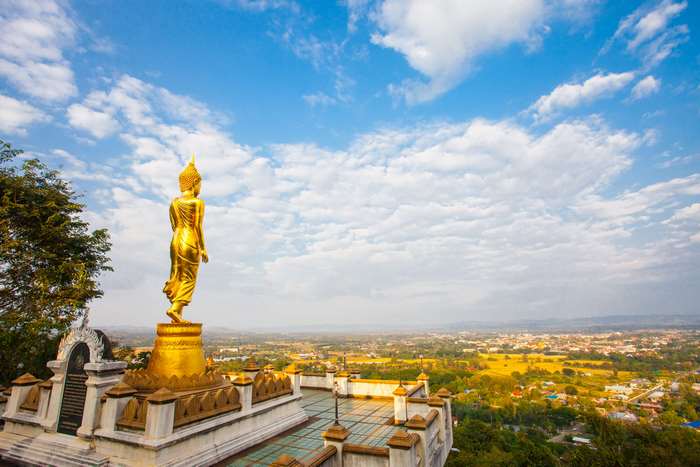 Golden Buddha statue overlooking a city in Thailand 4K