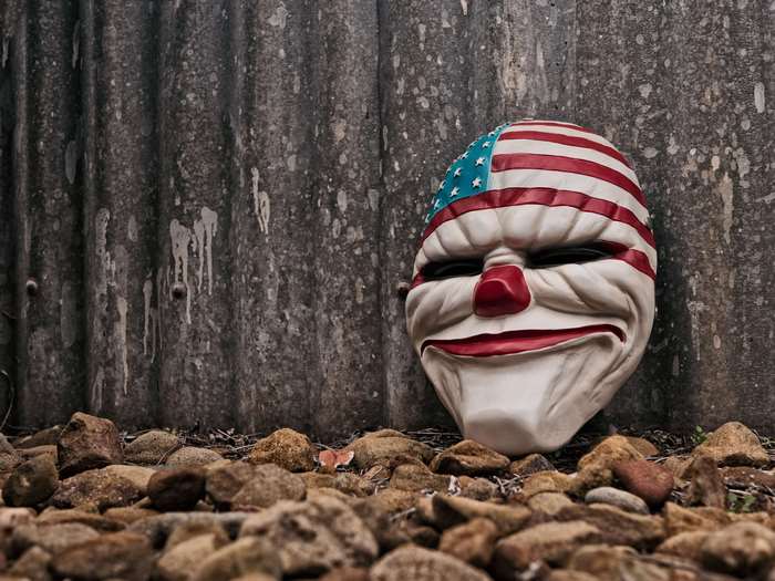 Creepy clown mask with American flag design on rocks