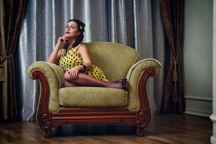 Woman in polka dot dress sitting in armchair