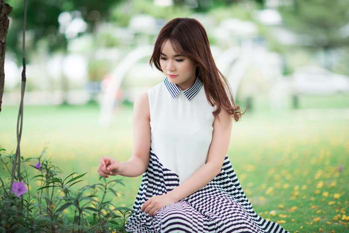 Young woman in a dress sitting in a park