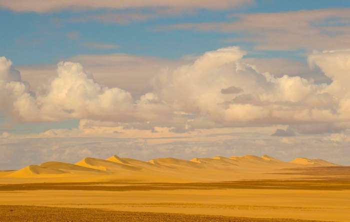 Desert sand dunes under a cloudy sky
