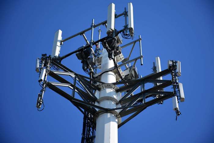 Cellular tower with antennas against a blue sky