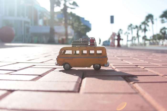 Miniature yellow taxi van with luggage on roof