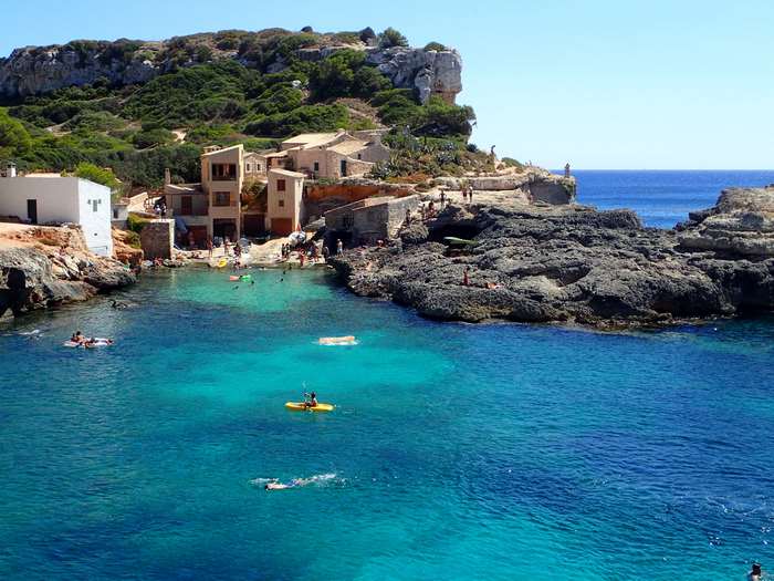 Kayaking and swimming in a turquoise cove in Mallorca, Spain