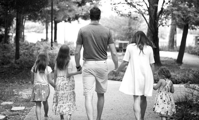Family holding hands walking in a park