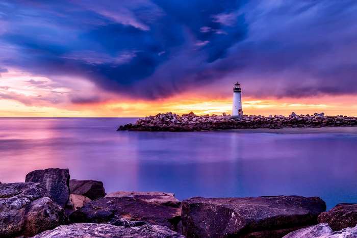 Lighthouse on a rocky jetty at sunset in Santa Cruz