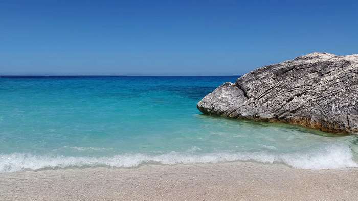 Beach with turquoise sea and rock in Sardinia