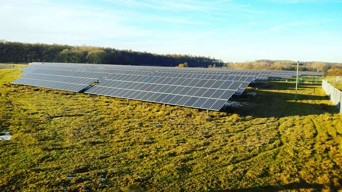 Solar panels in a field under a blue sky