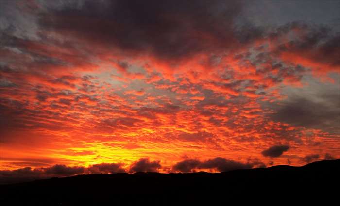 Dramatic sunset over silhouetted hills