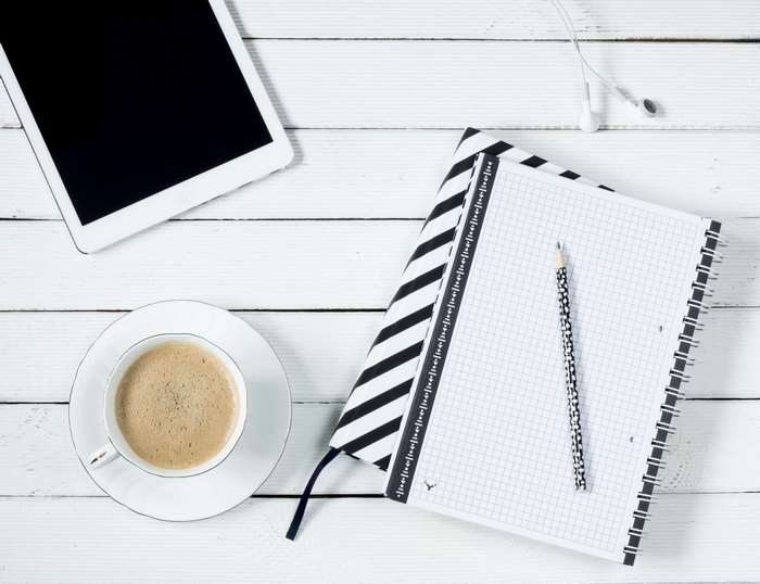 Tablet, Coffee, Notebook, and Pencil on White Table