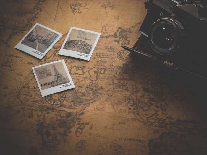Vintage camera and travel photographs on a map