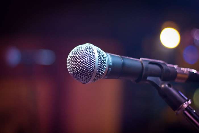 Shure microphone on a stand in front of bokeh lights