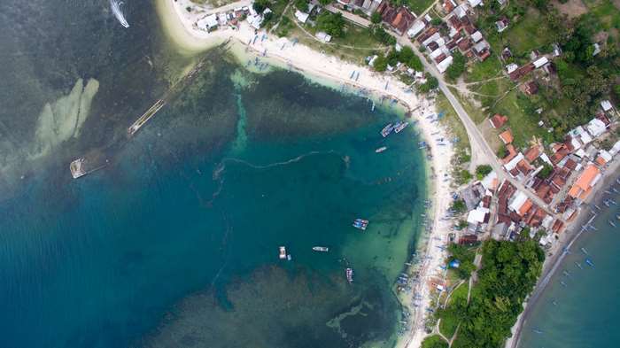 Aerial view of a coastal village with boats and a beach
