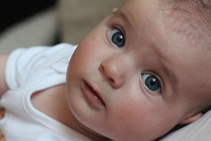 Baby with blue eyes wearing white