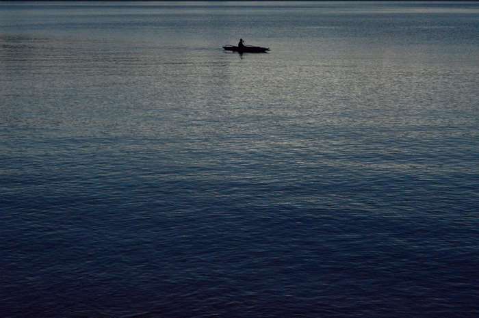 Man in a small boat on the deep blue sea