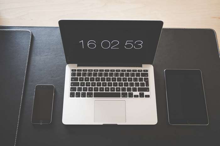Apple devices on a desk: MacBook, iPhone, and iPad