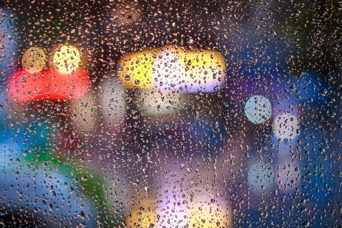 Raindrops on glass with blurred colorful lights