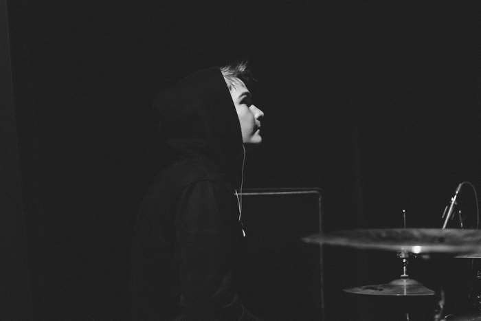 Musician in a hoodie with a drum set