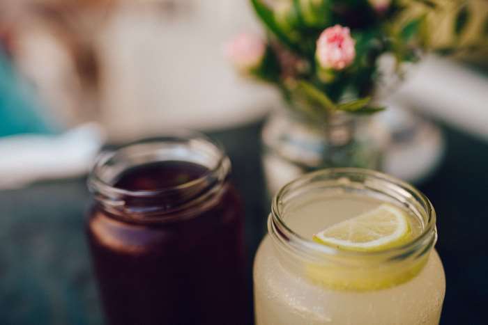 Two mason jars with drinks and flowers