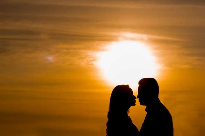 Couple silhouetted against a sunset