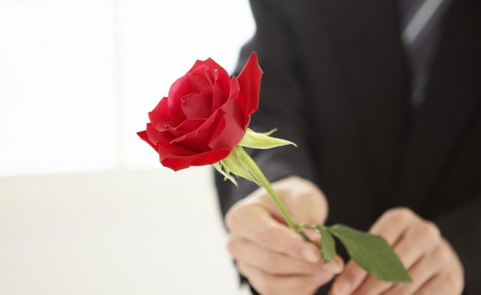 Man in Suit Offering a Red Rose