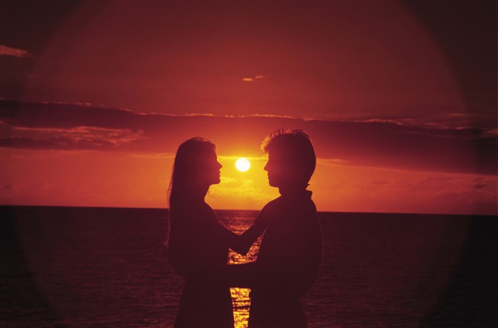 Couple embracing at sunset over the sea