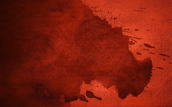 Red watercolor stain on textured surface