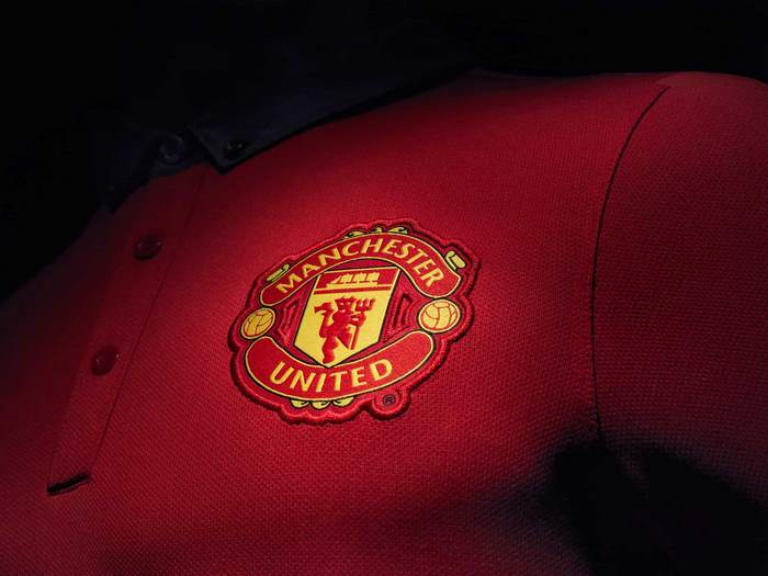 Manchester United football club crest on red shirt